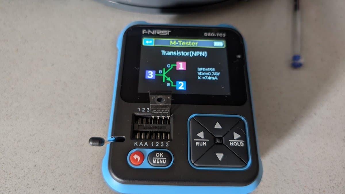 ANRITSU M-Tester DSO-TC3 displaying NPN transistor test results (hFE=191, Vbe=0.74V, Ic=74mA) during Wondermega regulator diagnostics.