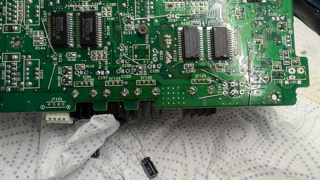 Wondermega mainboard with removed voltage regulators, scraped corrosion, and replaced electrolytic capacitors during restoration work.