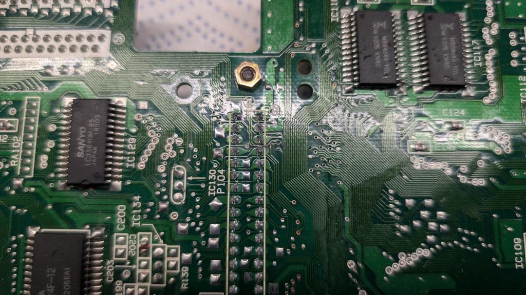 Close-up of Wondermega PCB showing re-soldered connector and kynar wire patch on broken trace repair work.