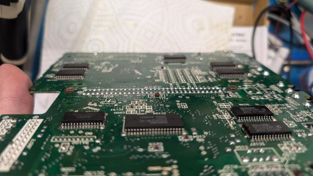 Close-up of Wondermega PCB showing drag-soldered connector and kynar wire patch repair on broken trace.