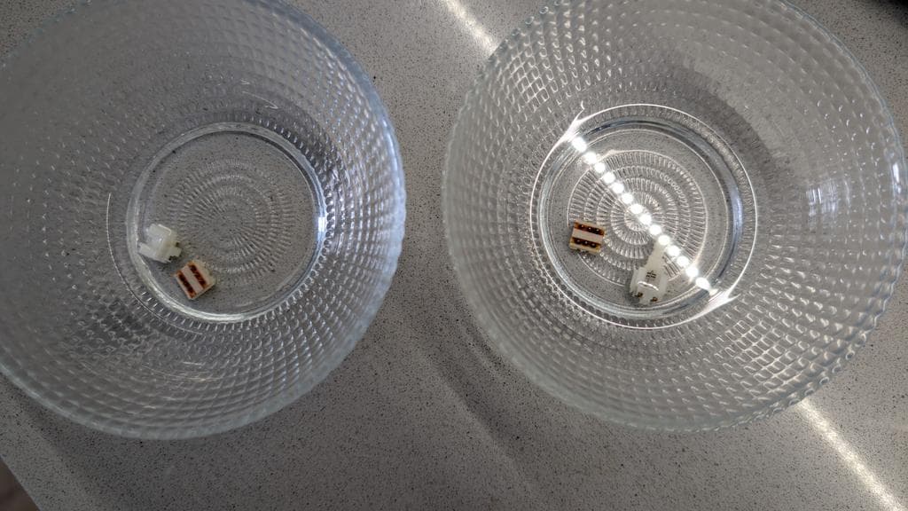 Two desoldered Wondermega power and reset buttons showing corroded metal contacts and component legs after removal from circuit board.