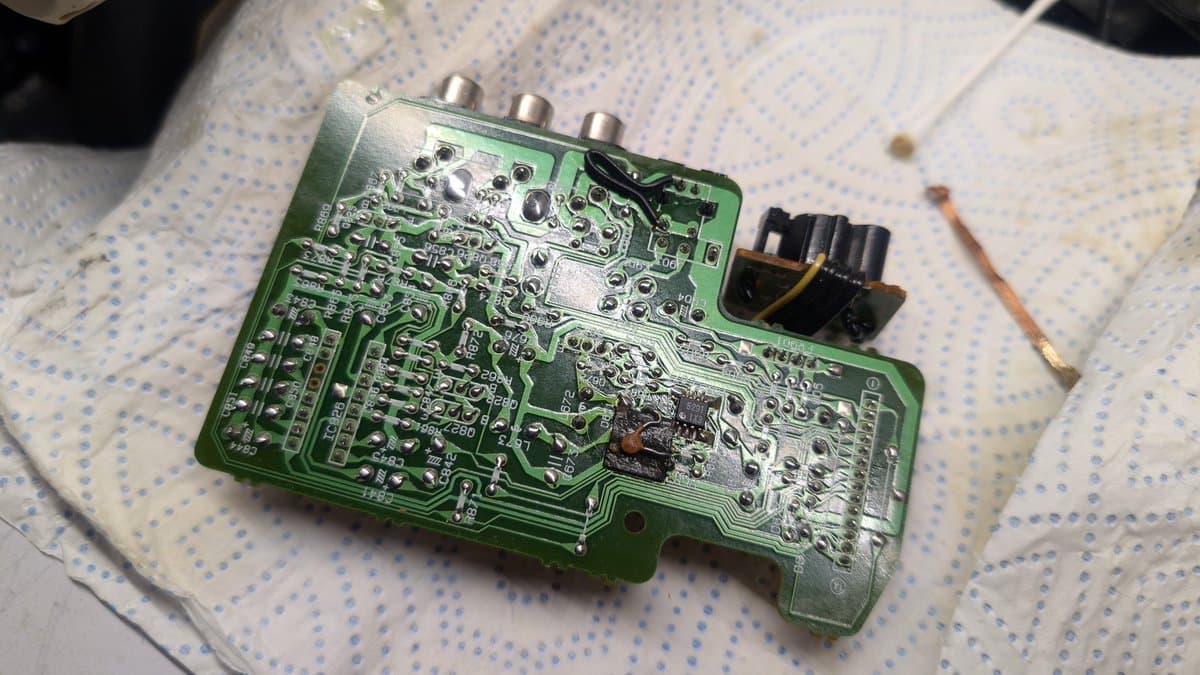 Wondermega AV board with partially recapped electrolytic capacitors and reflowed solder joints, green PCB with three RCA connectors visible.