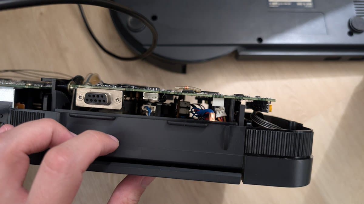 Wondermega optical drive assembly with disconnected cables; internal circuitry, connectors, and motor mechanism visible during troubleshooting.