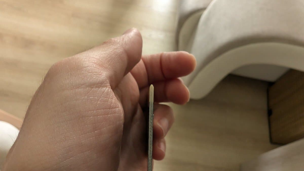 Hand holding flash kit programmer cartridge with beveled edge near Sega Wondermega console for 240p test suite installation.