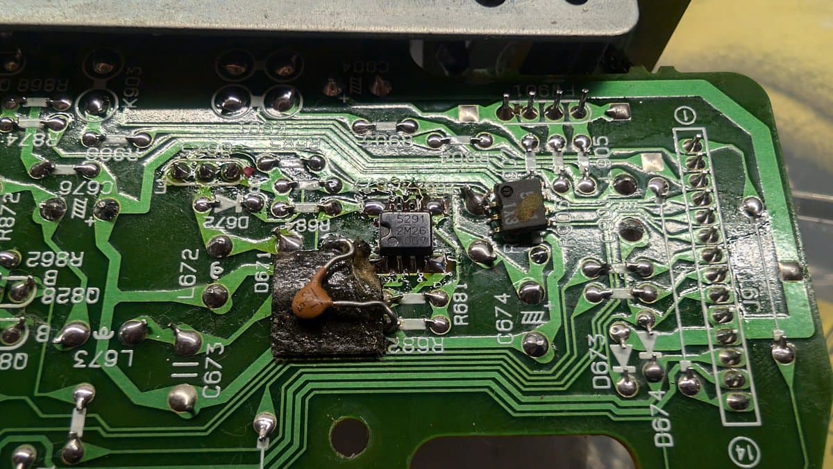 Wondermega AV board showing replaced transistor and DC-DC converter with visible corrosion and oxidation damage around components.
