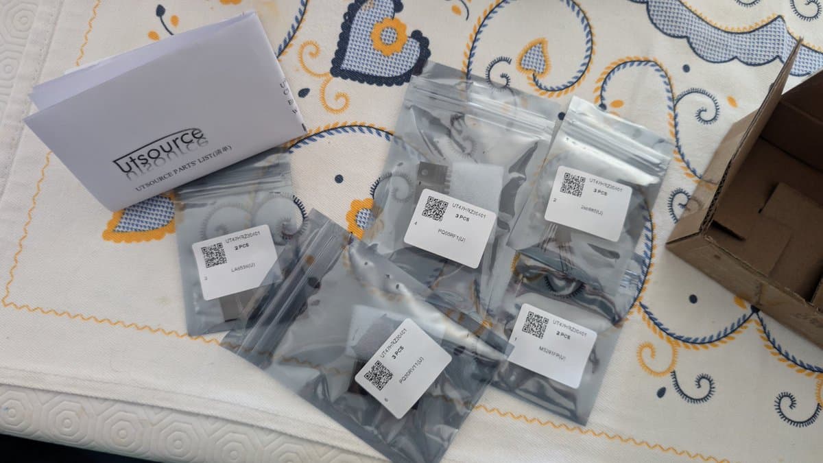 UTSource parts kit with labeled transistors and regulators in antistatic bags, component tester verification for Wondermega repair.