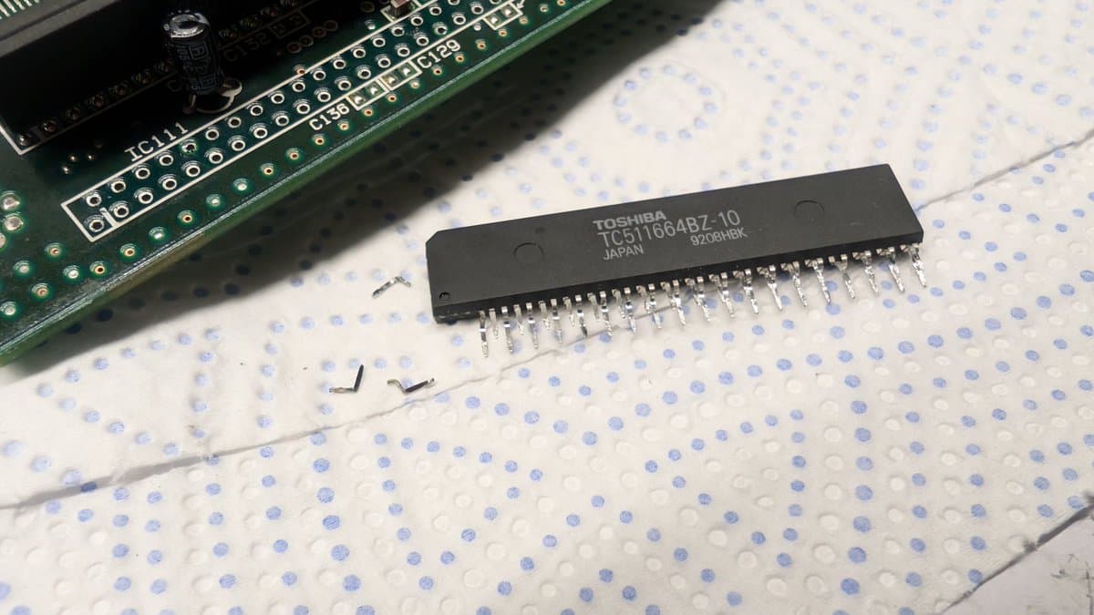 Toshiba TC51664RZ-10 RAM chip with 3 broken legs removed from Wondermega board, displayed on breadboard.