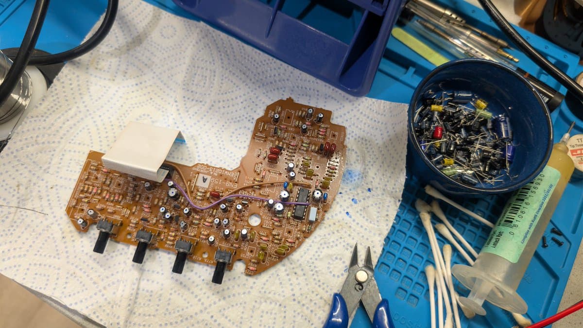 Wondermega Victor RG-M1 audio/karaoke effects and laser boards after recap, on work mat with tweezers, component bin, and ruler nearby.