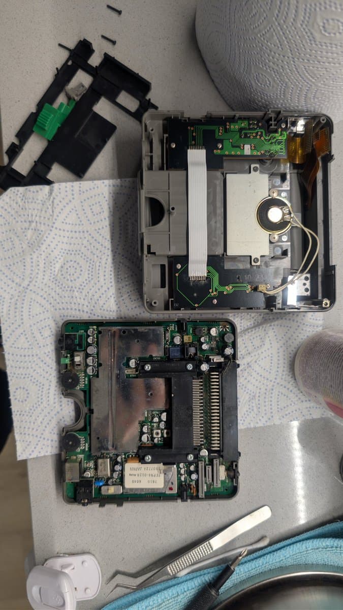 Disassembled PC Engine LT showing removed LCD panel, logic boards, and internal components laid out during repair diagnostics.
