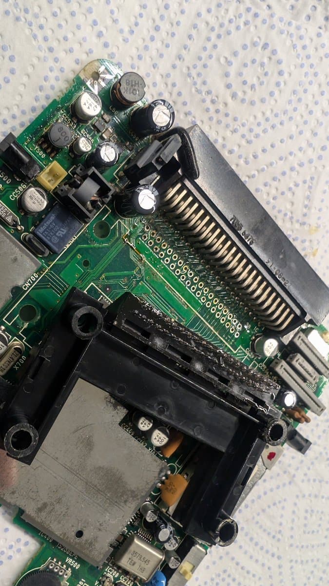 PC Engine LT motherboard showing corrosion damage near 6.5V regulator and HuCard slot area during cleaning and inspection.