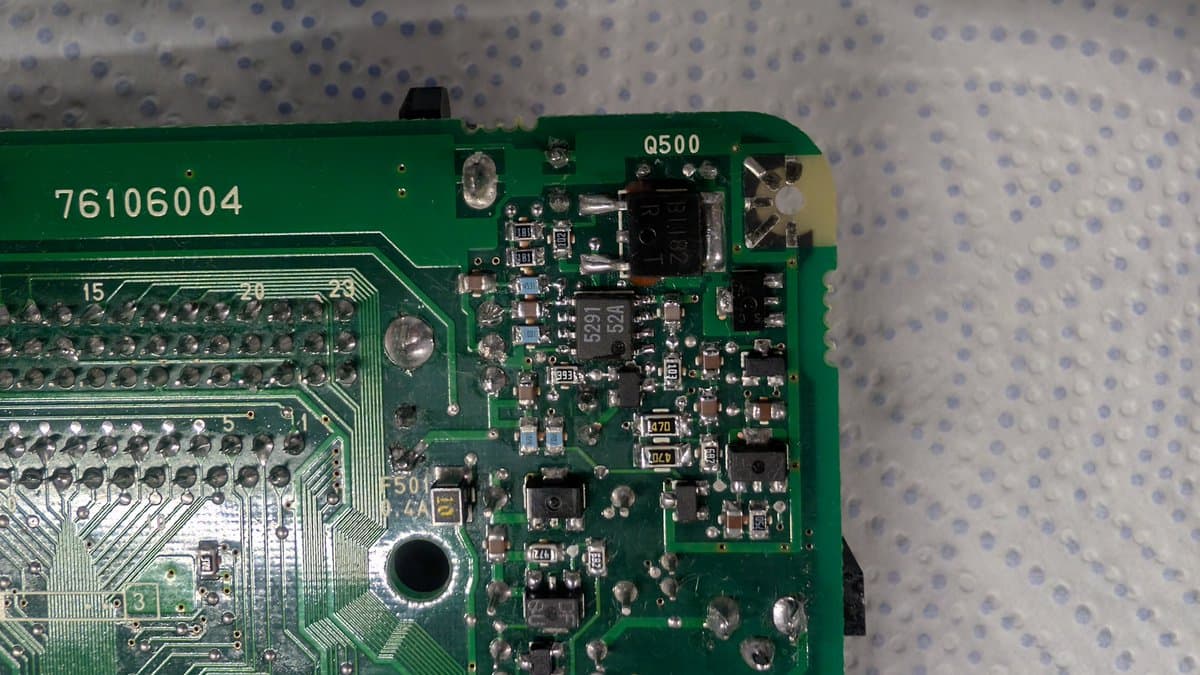 Close-up of PC Engine LT circuit board showing M5291FP voltage regulator (Q500) and surrounding SMD components during repair work.