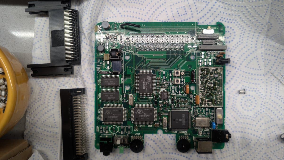 NEC PC Engine LT mainboard after ultrasonic cleaning, showing multiple IC chips, capacitors, and connectors on green PCB with no visible trace damage.
