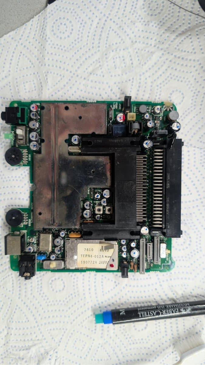 PC Engine LT motherboard with new capacitors installed, showing recapped power delivery section and inspection markers during troubleshooting.
