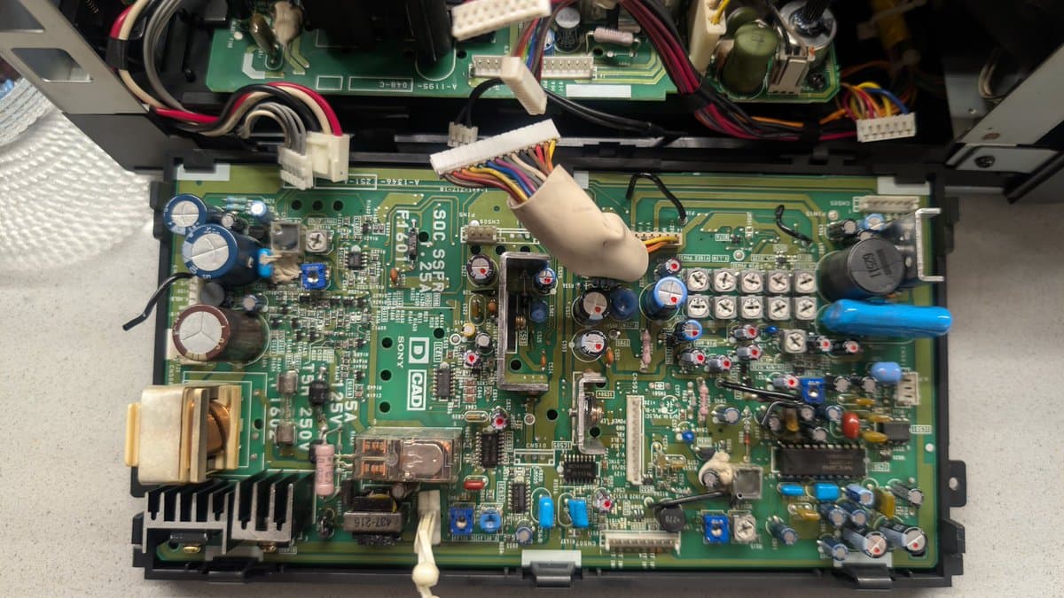 Sony PVM-9045QD main board with freshly reflowed solder joints, new capacitors marked with dots, power supply and deflection circuits visible.