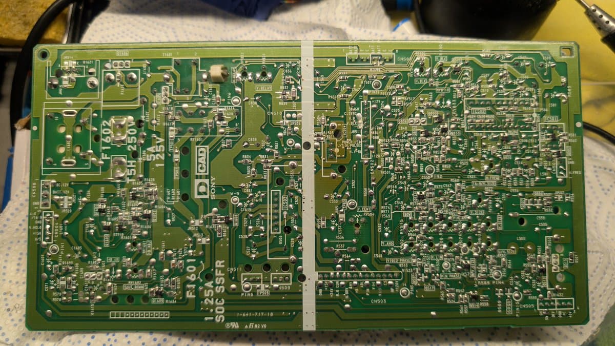 Sony PVM-9041Q deflection board with freshly soldered capacitors marked with dots; shiny solder joints visible on reverse side.