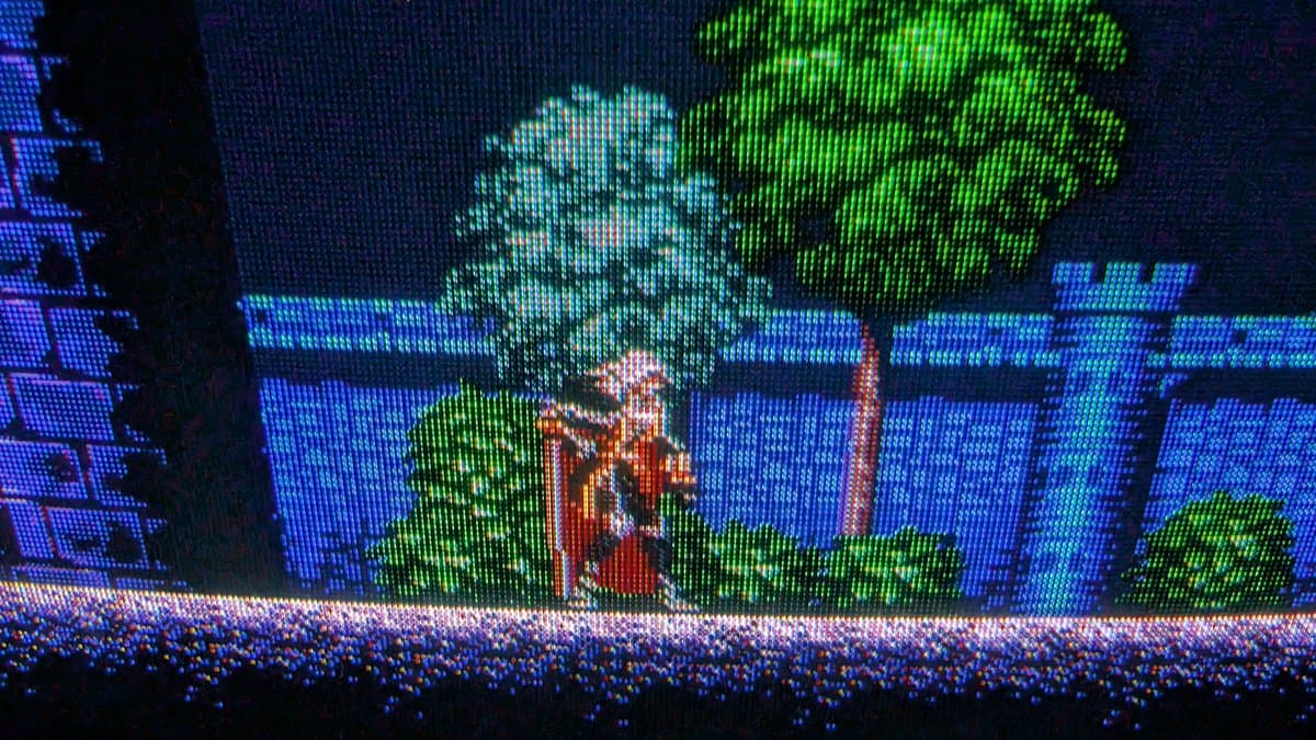 Restored Sony PVM-9045QD displaying pixel-perfect 16-bit retro game graphics with vibrant blue castle, green foliage, and red door.