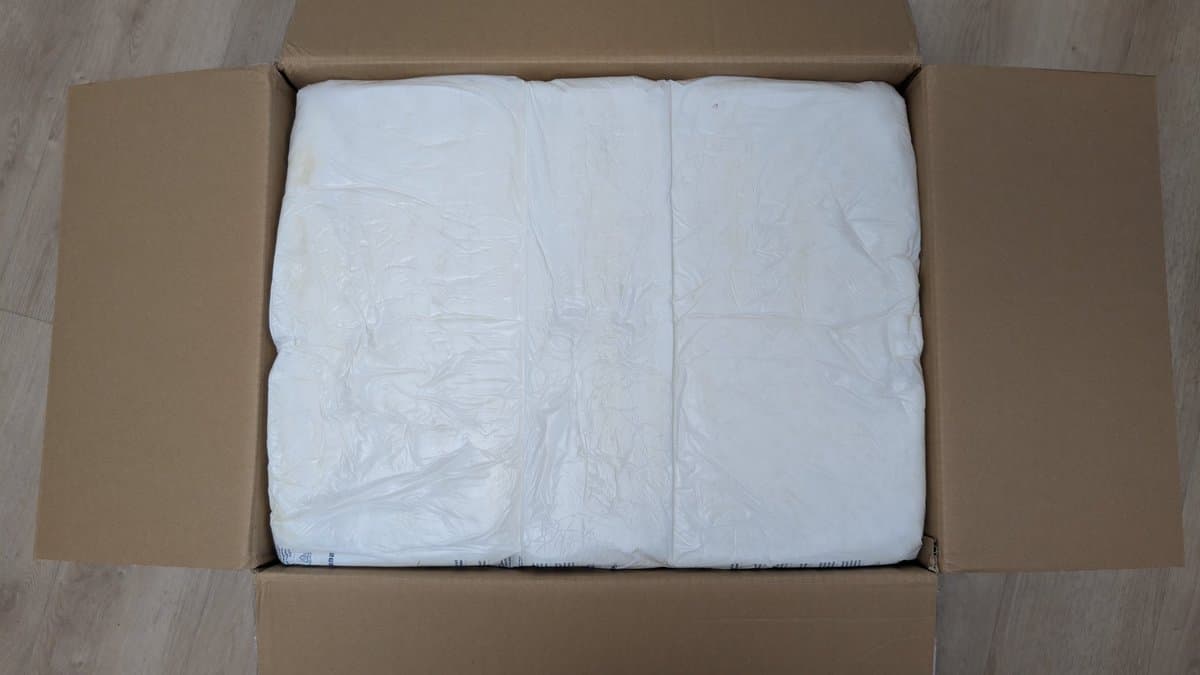 Unboxed Sharp X68000 tower model wrapped in white protective plastic inside cardboard shipping box.