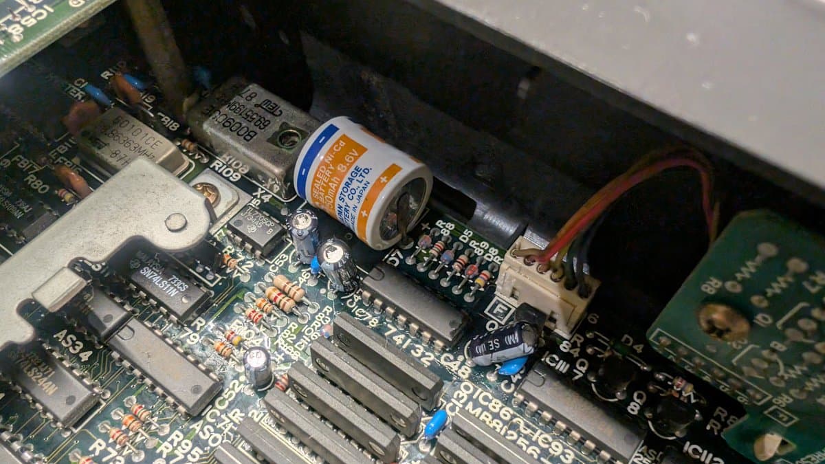 Battery leakage corrosion on X68000 mainboard cleaned with vinegar and isopropyl alcohol; capacitor visible.