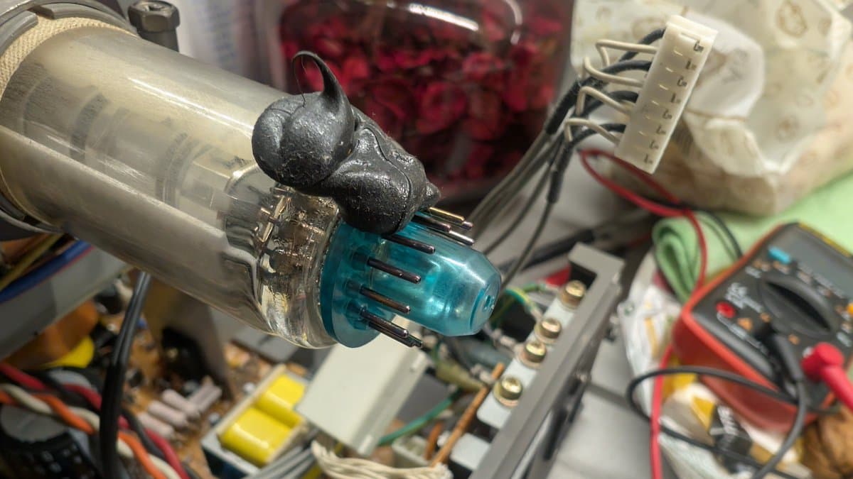 Close-up of CRT tube pins being cleaned with fiberglass pen and IPA/Deoxit to remove oxidation during PVM-14L1 RGB mod maintenance.