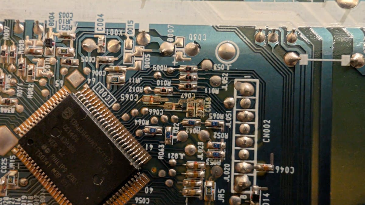 Close-up of RGB mod PCB assembly for PVM-14L1, showing soldered components, resistors, capacitors, and IC chip with copper traces on blue circuit board.