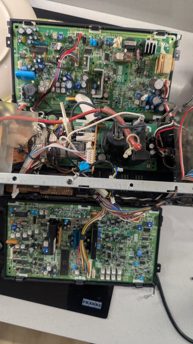 Interior view of Sony PVM-6041Q showing main PCB and deflection board with cleaned components, reassembled wiring, and capacitors after restoration.