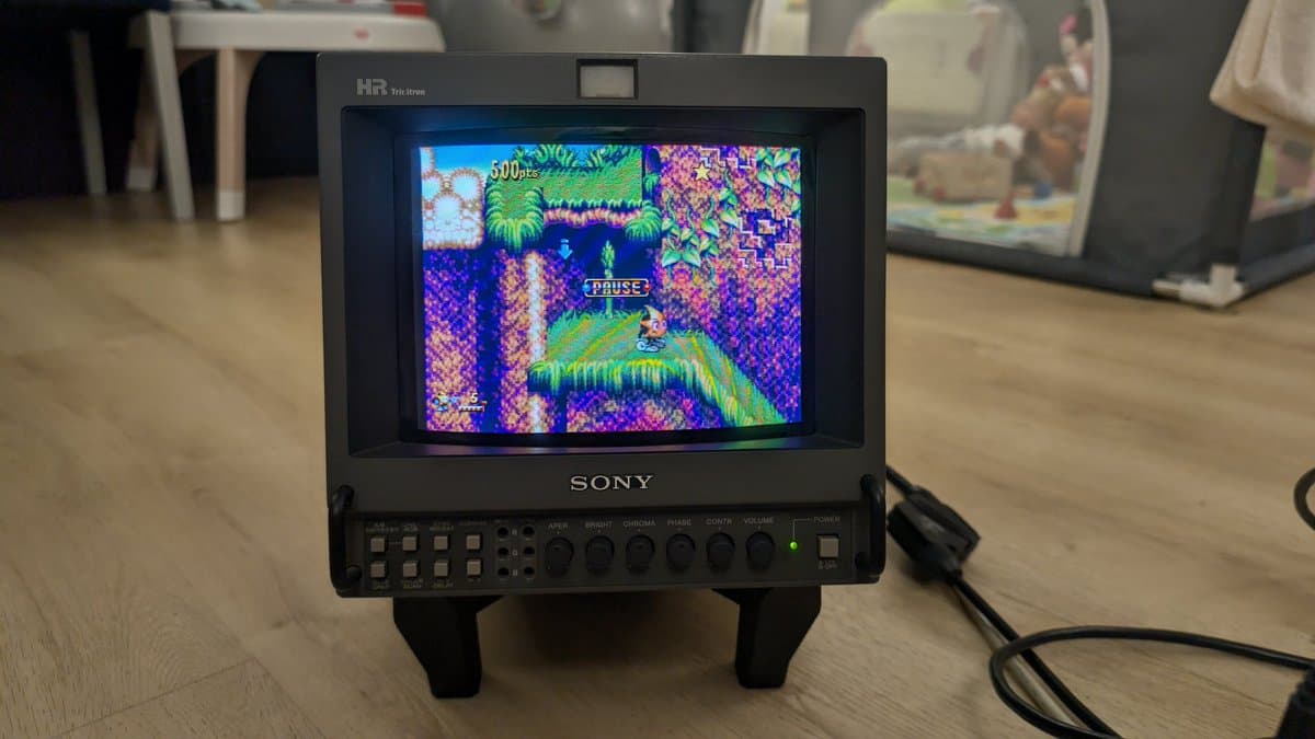Sony PVM-9045QD on 3D-printed stand displaying paused retro game; restored after PSU, neck board, deflection board repairs.