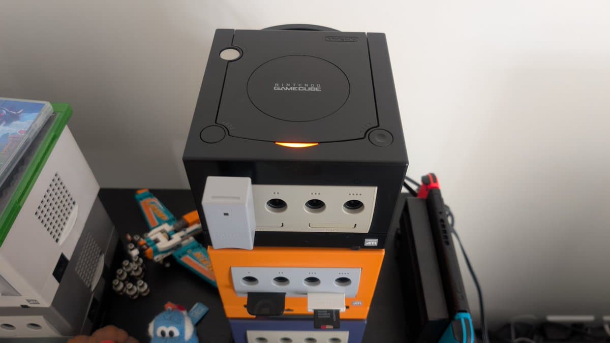 Black Nintendo GameCube with orange controller ports visible, displaying PicoBoot installation with WiiKey storage interface during restoration.