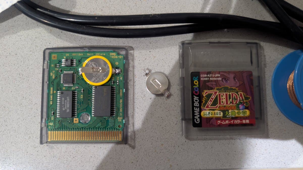 Two Game Boy cartridges with fresh CR2032 batteries installed; left shows green PCB with yellow battery holder circled, right displays Zelda: Link's Awakening cart.