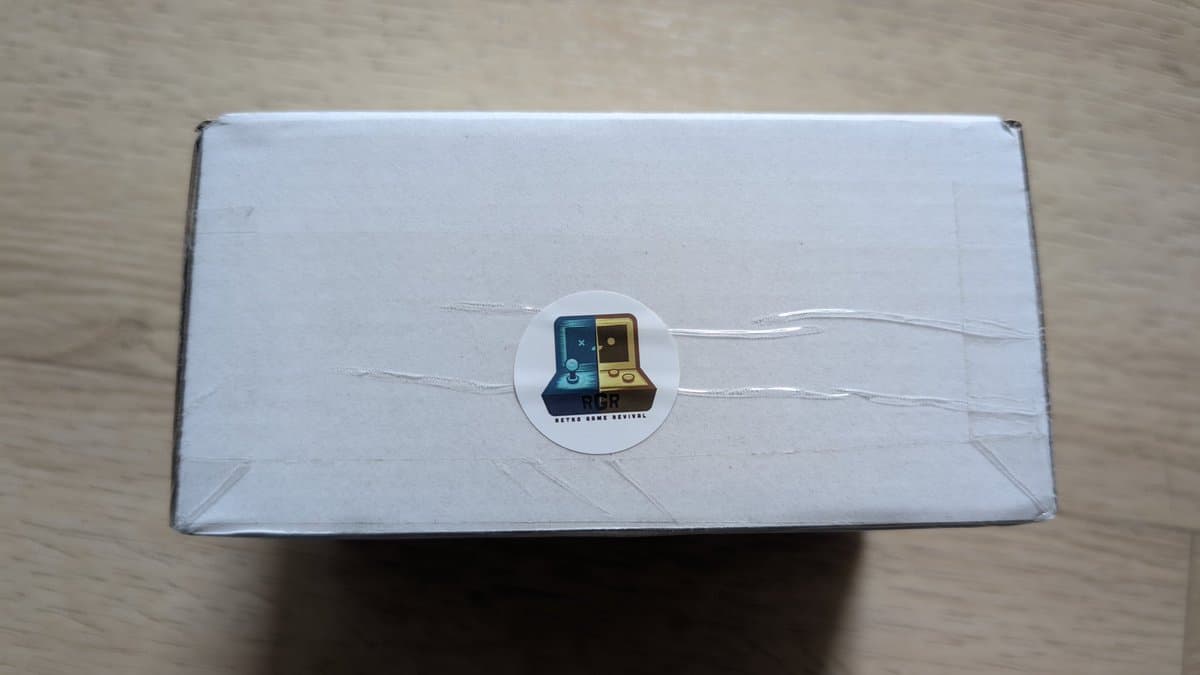 White box with circular Sega Game Gearish logo sticker, containing aftermarket Nomad battery pack from PointerFunction.